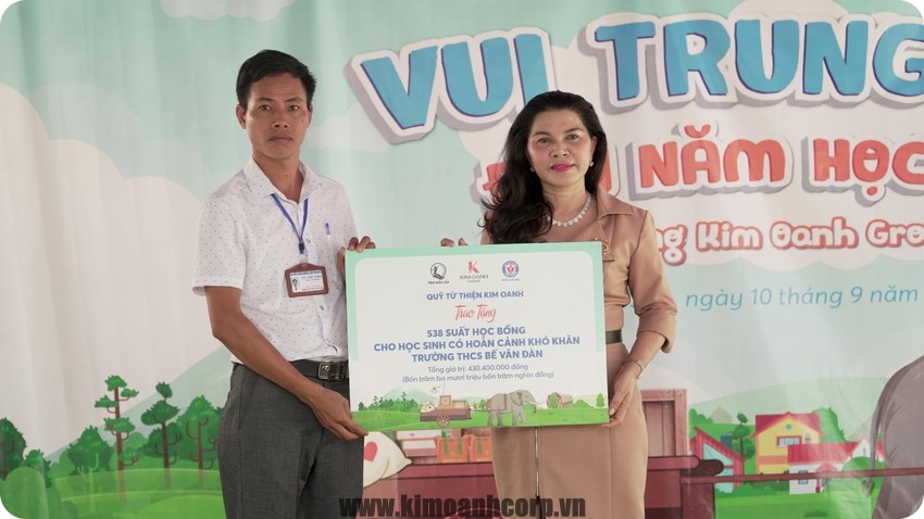 Bà Đặng Thị Kim Oanh trao bảng tượng trưng 538 suất học đến trường Trung học cơ sở Bế Văn Đàn.